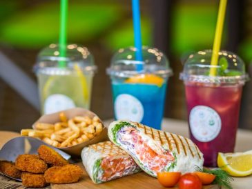 A vibrant array of drinks paired with a delicious wrap, fries, and nuggets.