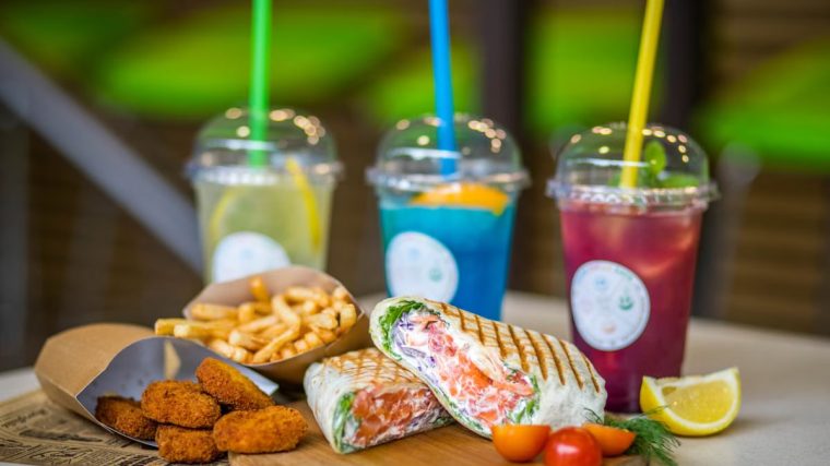 A vibrant array of drinks paired with a delicious wrap, fries, and nuggets.